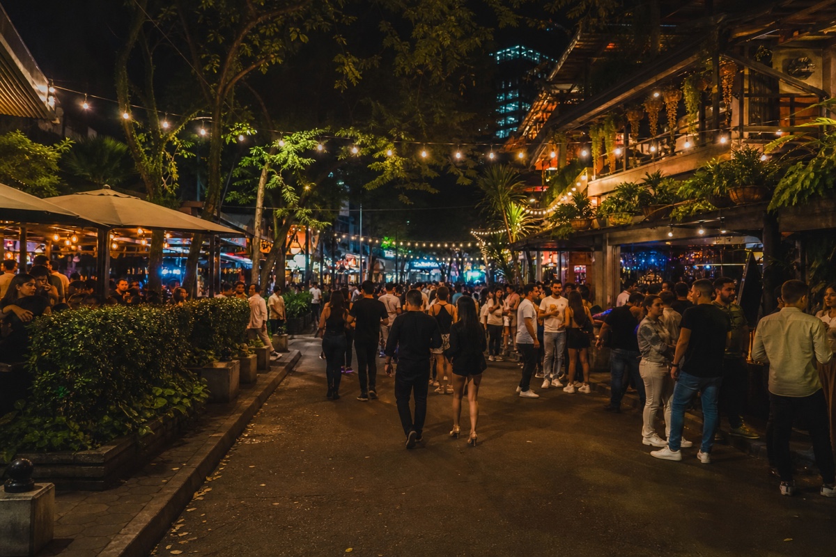 El Poblado in Medellin at night, Parque Lleras area, bars and string lights and a busy street scene without a clear couple in frame